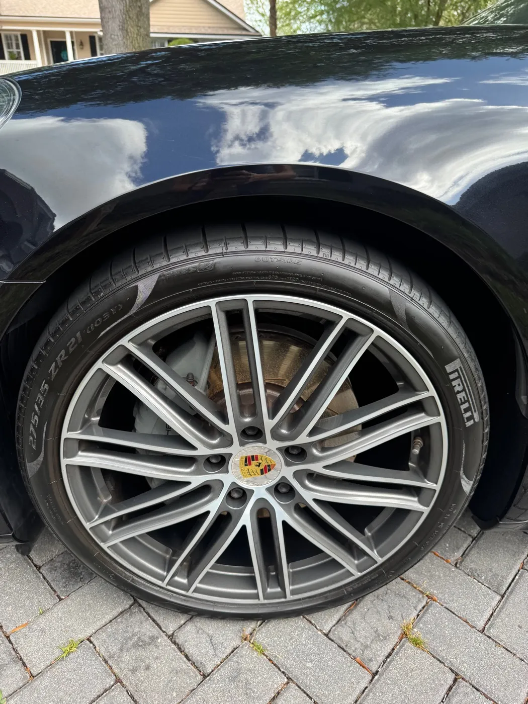 Porsche wheel and glossy black fender after a detail